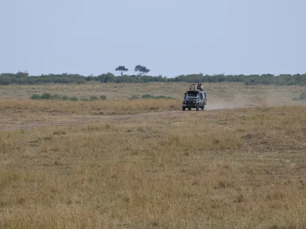 A safari vehicle paused on a red-earth track during a private Kenya journey